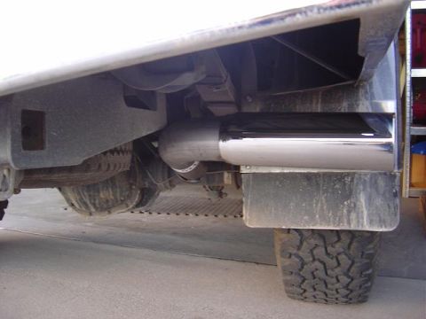 1986 Ford Bronco II - Close-up view of a vehicle's rear axle and chrome exhaust pipe, showing suspension components.