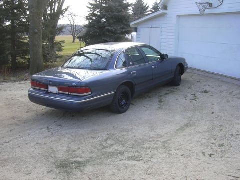 1996 Ford Crown Victoria - This 1996 Ford Crown Victoria is parked outside a garage on a cloudy day.