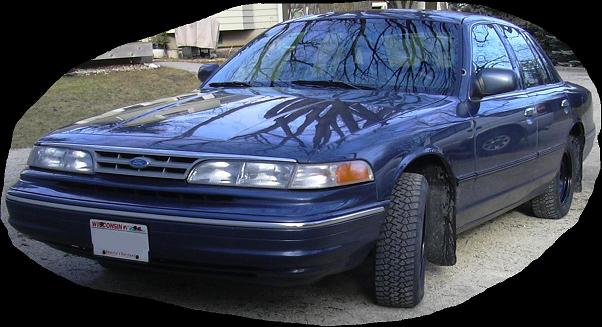 Blue Ford Crown Victoria sedan, front three-quarter view in gravel driveway, oval vignette edit