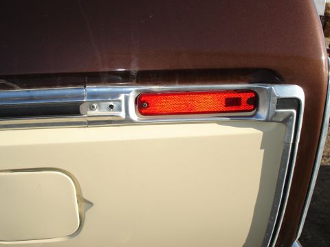 1979 Ford Bronco - This photo shows the rear corner of a vehicle with a red reflector and chrome trim, along with a fuel door.
