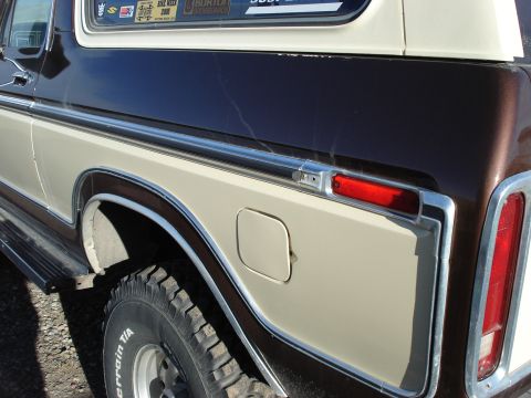 1979 Ford Bronco - The rear quarter panel of a two-tone brown and beige Ford Bronco shows its fuel door and taillight assembly.
