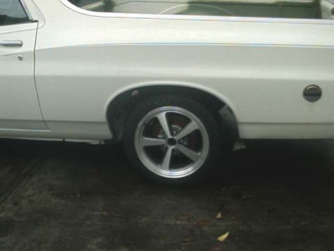 1976 Ford Ranchero - Side view of a 1976 Ford Ranchero, focusing on the rear wheel and truck bed area.