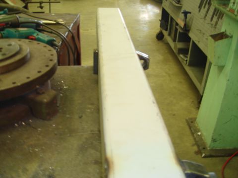1996 Ford Bronco - A metal beam is clamped in a vise, with tools and machinery visible in the workshop setting.