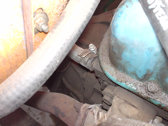 Close-up of engine parts, including hoses and a blue valve cover