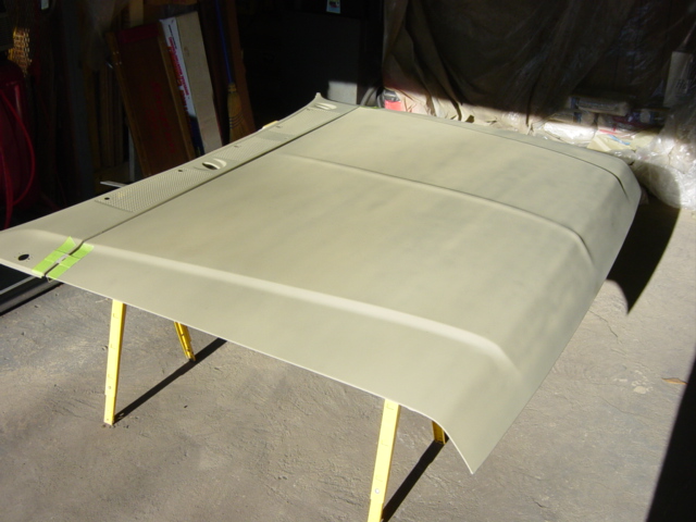 Car hood on yellow sawhorses, taped at the edge