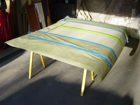 1991 Ford Bronco - Car door prepped for paint, covered in masking paper and tape, supported by sawhorses.