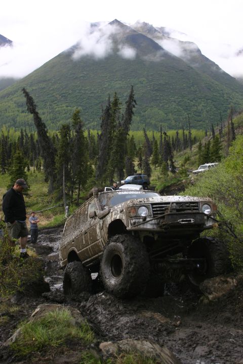 2003 Jeep TJ - An off-road vehicle struggles through a muddy and rocky terrain during an event in Alaska.