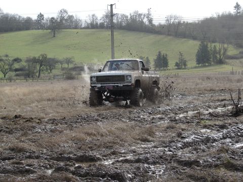 1996 Ford Bronco - Pickup truck navigates a challenging muddy terrain, demonstrating off-road capability.