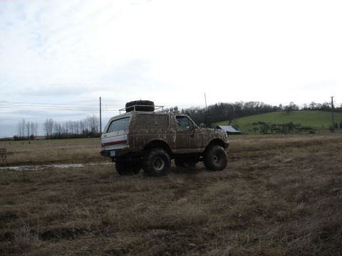 1996 Ford Bronco - This heavily modified SUV, likely from the early to mid-1990s, is covered in mud after off-roading.