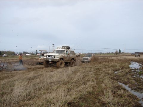 1996 Ford Bronco - This 1996 Ford Bronco is shown participating in a muddy off-road event, with other vehicles also present in the scene.