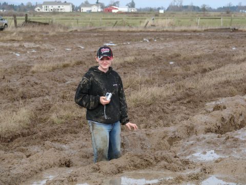 1996 Ford Bronco - A person stands in a muddy field, holding a camera and wearing a camouflage hoodie.