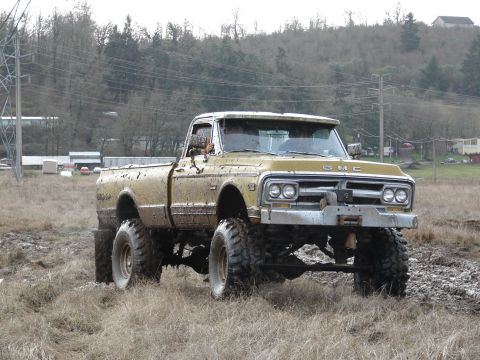 1996 Ford Bronco - This lifted GMC pickup truck is covered in mud after an off-road excursion.