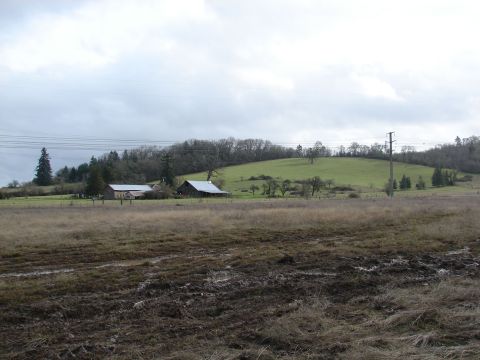 1996 Ford Bronco - Rural landscape features barns on a grassy hill with a muddy field in the foreground.