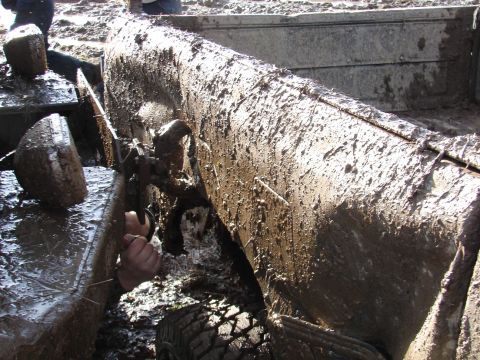 1996 Ford Bronco - A vehicle is deeply stuck in mud, with a person's hand reaching out from the side.