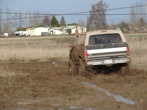 1996 Ford Bronco - 1996 Ford Bronco rear view navigating a muddy off-road course.