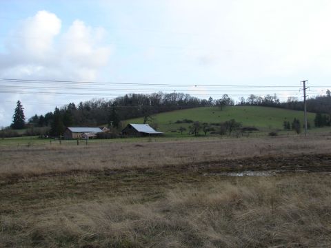1996 Ford Bronco - A wide view of a rural property barns and grassy hills, with power lines overhead.