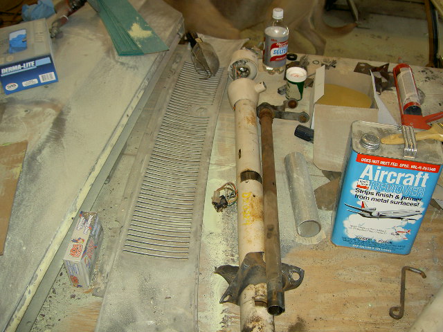 Steering column, grille, and various automotive chemicals on a workbench