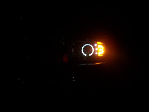 2001 Dodge 1500 - Close-up of a vehicle's illuminated headlight assembly at night.