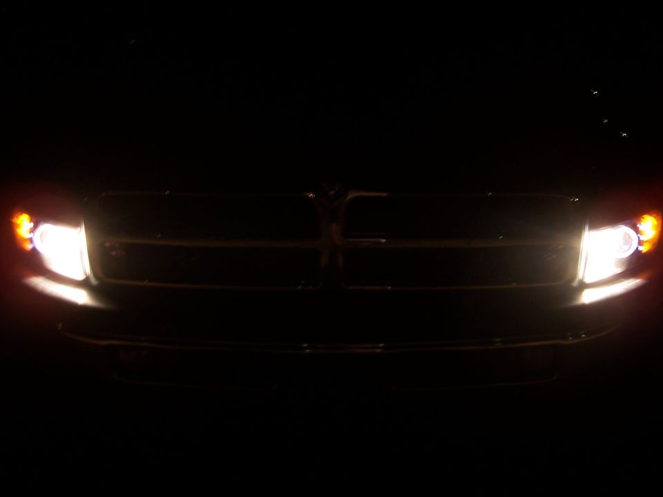 Dodge Ram crosshair grille lit by its own headlights at night