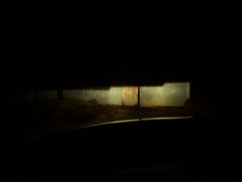2001 Dodge 1500 - The beam from the headlights illuminates a section of a corrugated metal wall and a pile of dirt.