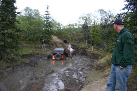 2003 Jeep TJ - A Jeep TJ navigates a challenging muddy obstacle during an off-road event.
