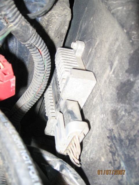 1994 Ford Bronco - Detail of an automotive electrical part, likely a voltage regulator or similar component, with visible wiring and connectors.