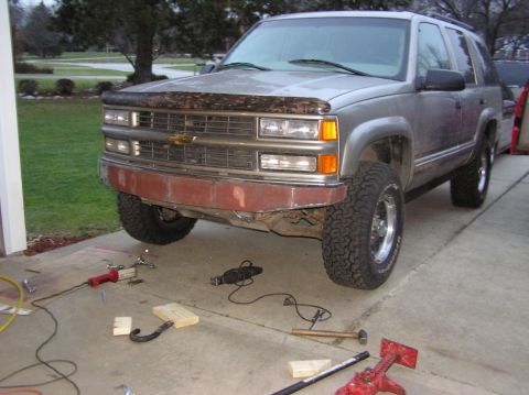 2000 Chevrolet Tahoe - A silver Chevrolet Tahoe is parked in a driveway with tools scattered around its front bumper.