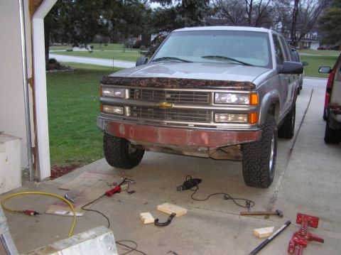 2000 Chevrolet Tahoe - This silver SUV features an aftermarket front bumper and lifted suspension, suggesting a custom build. The grille indicates a mid-1990s mod…