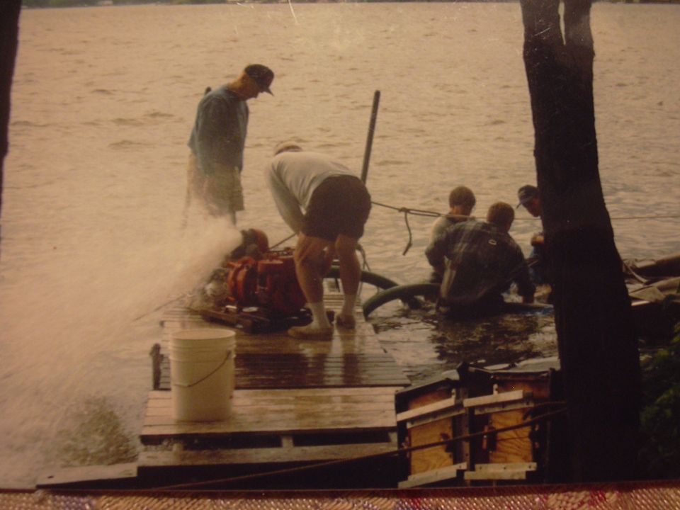 Red engine on a wooden dock with people working around it