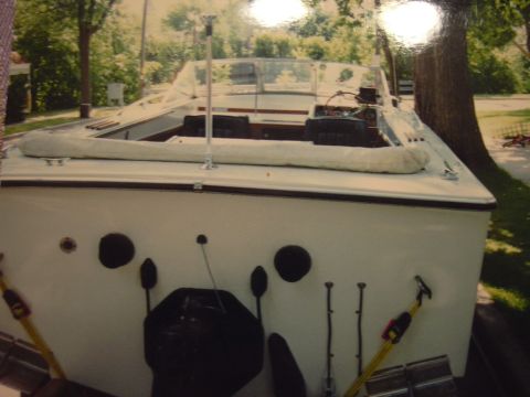 1977 Ford F-150 - The rear view of a white boat shows its interior and windshield, parked outdoors.