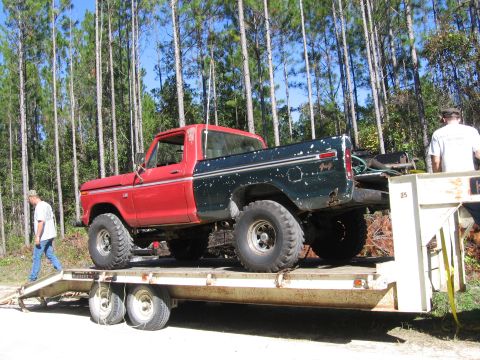 1974 Ford F-100 - Ford F-100 pickup truck loaded onto a trailer, with two men standing near the vehicle and trailer.