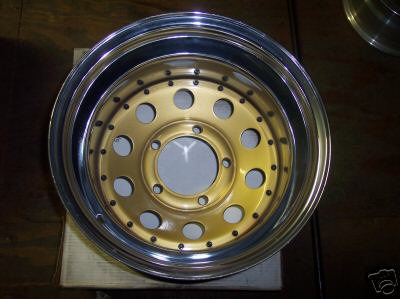 1991 Ford Bronco - A gold and chrome wheel with a multi-hole design is shown, with Supermotors.net branding visible.