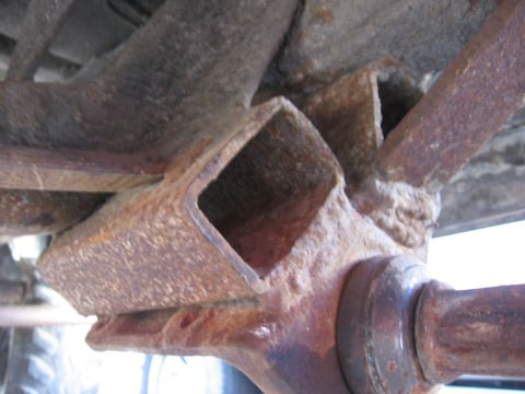 1974 Ford F-100 - Close-up view of heavily rusted frame components, including a square metal support, with a Supermotors logo visible at the bottom right.