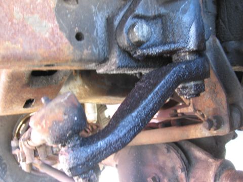 1974 Ford F-100 - Detail of a vehicle's steering linkage, showing significant rust and grease accumulation.