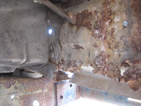 1974 Ford F-100 - Close-up of severe rust damage on a vehicle's frame rail.