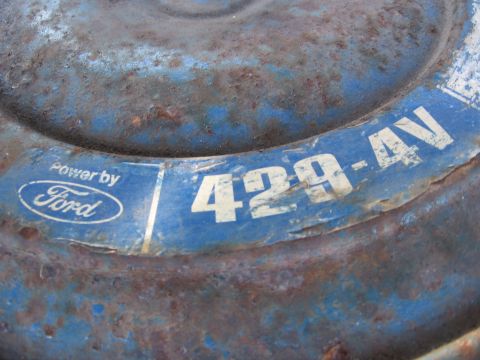 1974 Ford F-100 - This close-up shows a blue, rusty engine part with 'Power by Ford' and '429-4V' markings.