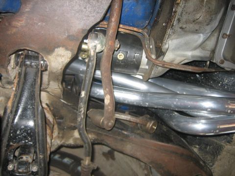 1976 Ford Ranchero - Underside view of a vehicle's exhaust manifold and starter motor components.