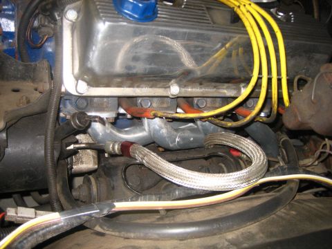 1976 Ford Ranchero - Close-up view of engine components, including the exhaust manifold and wiring harness.