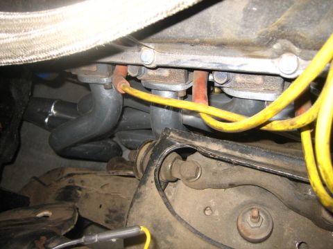 1976 Ford Ranchero - Close-up view of exhaust manifold pipes and spark plug wires on an engine.