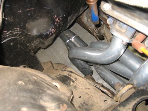 1976 Ford Ranchero - Close-up view of exhaust manifold pipes, showing welds and surrounding engine parts.