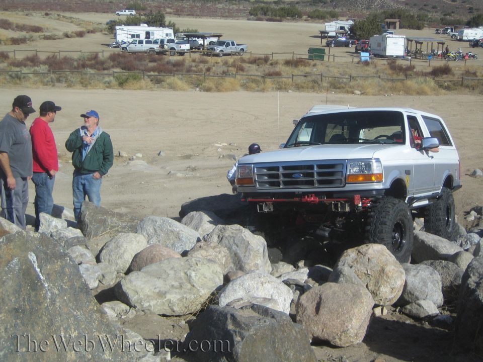 White Ford Bronco climbing over rocks on a trail