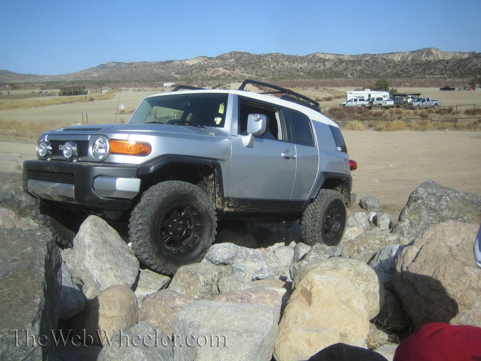 Silver Toyota FJ Cruiser with white roof navigating rocks