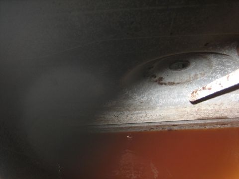 1976 Ford Ranchero - Underside view of a vehicle's rusty fuel tank and suspension parts.