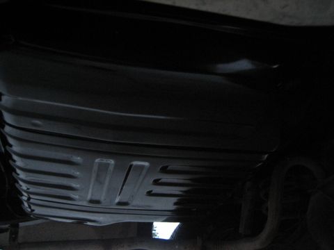 1976 Ford Ranchero - Underside view of a black gas tank with distinctive ridging and cutouts.