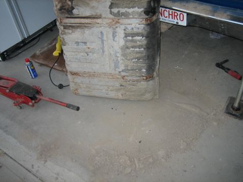 1976 Ford Ranchero - Gas tank and tools on concrete floor. License plate visible in background reads 'NCHRO'.