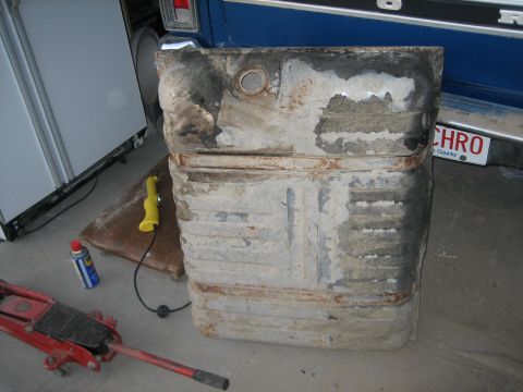 1976 Ford Ranchero - A rusty, used gas tank sits on the ground next to a jack and a can of spray.