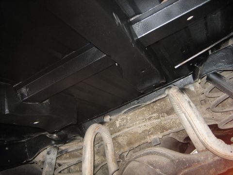 1976 Ford Ranchero - Underside view of a vehicle's chassis, black undercoating and exposed exhaust components.