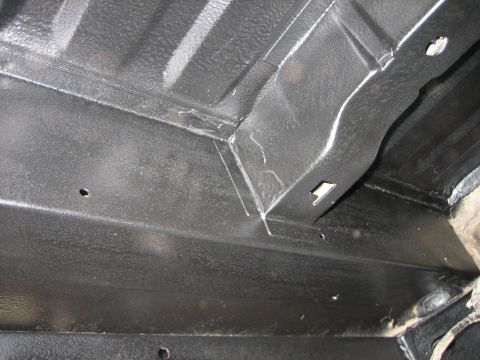 1976 Ford Ranchero - Underbody of a vehicle showing frame rails and floor pan with protective coating.