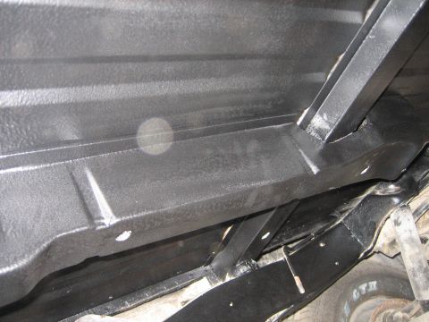 1976 Ford Ranchero - The underside of a vehicle shows black painted frame rails and a gas tank, with a SuperMotors.net watermark.