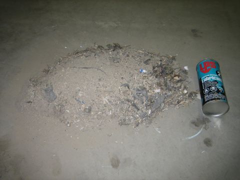 1976 Ford Ranchero - Debris pile and a can of LPS lubricant on a concrete floor.